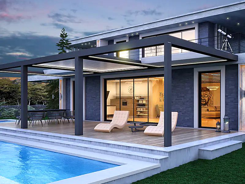 A dark grey pergola with a sliding roof over sun loungers beside a villa pool