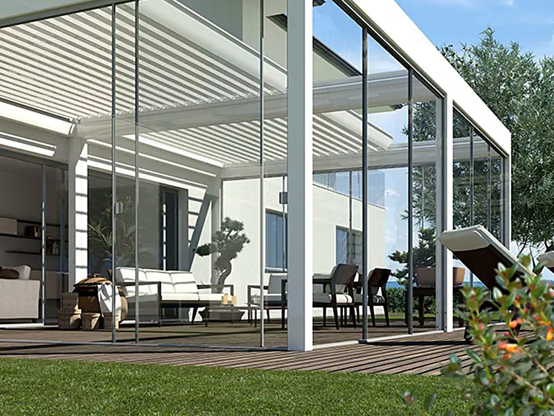 Sliding glass panels enclosing a white louvred pergola on a garden deck